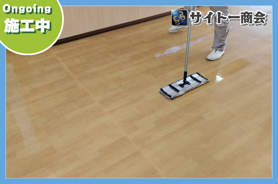 広いフロアに新しい床ワックスを塗り広げている様子
